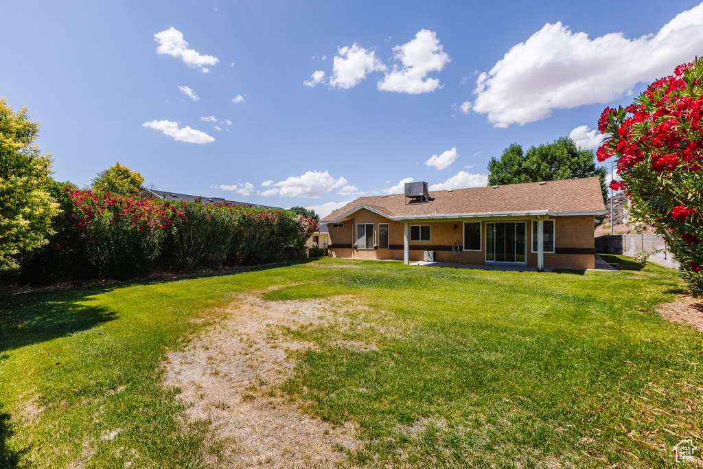 Back of property featuring stucco siding, a yard, a patio area, and central AC unit