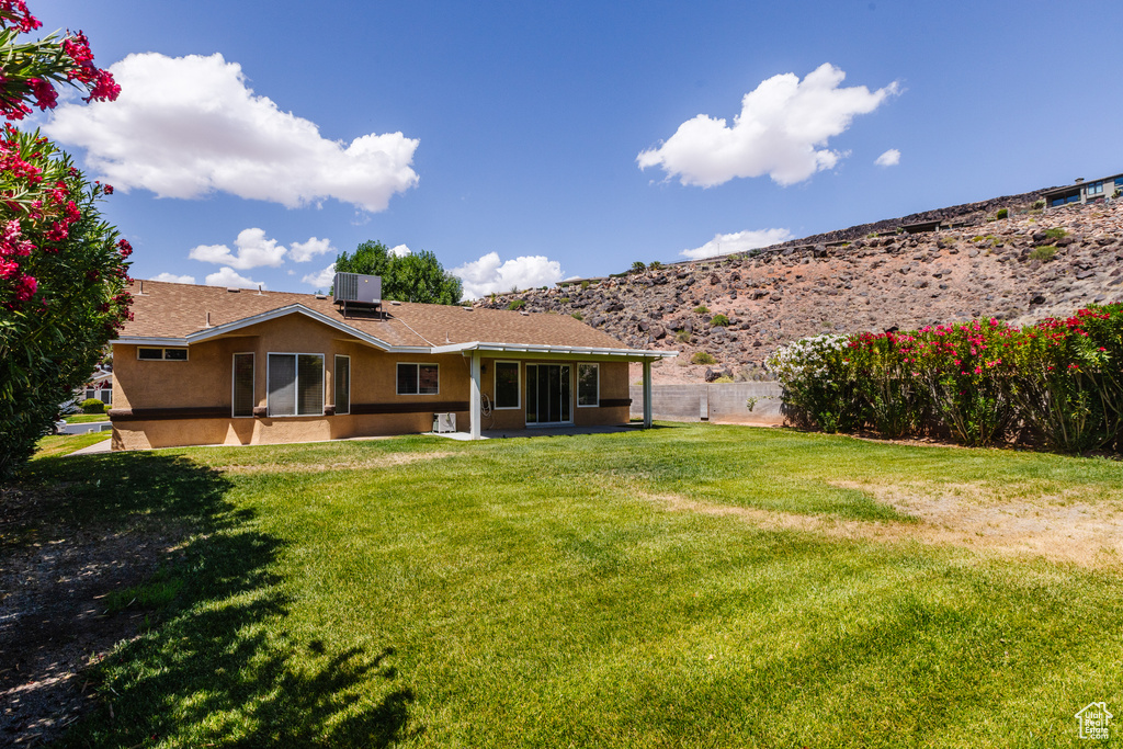 Rear view of property featuring stucco siding, central air condition unit, and a shingled roof