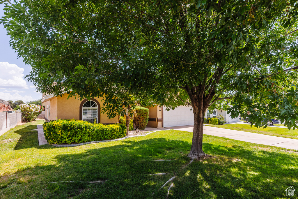 Obstructed view of property featuring stucco siding, driveway, and an attached garage