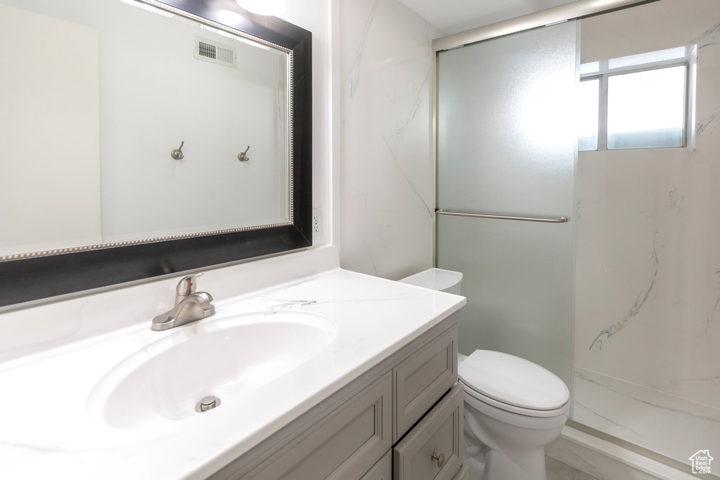 Bathroom with vanity and a marble finish shower