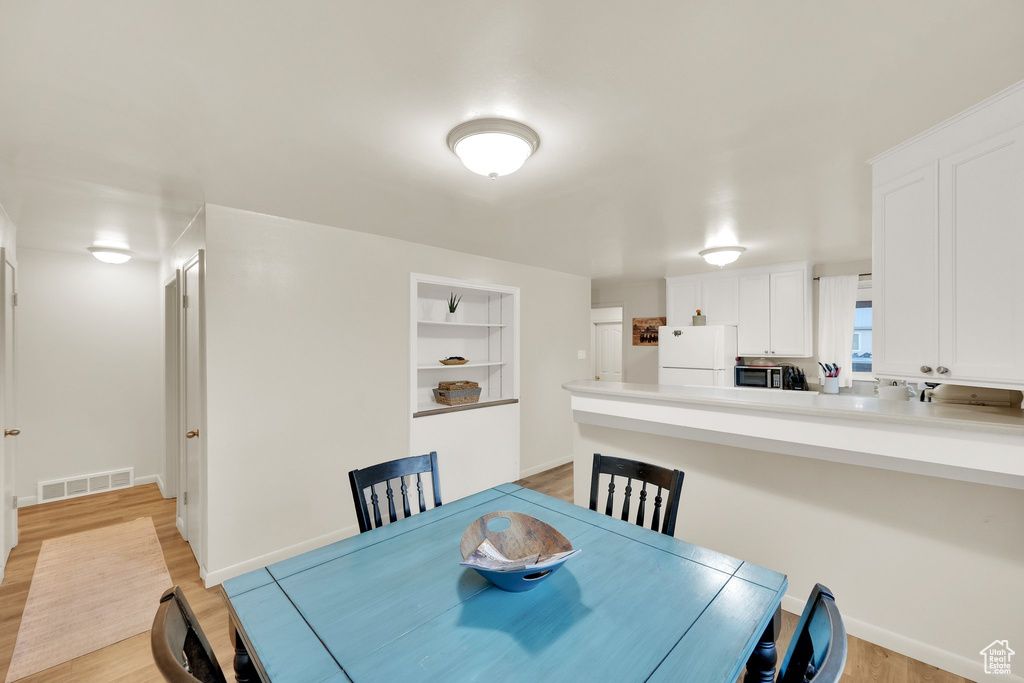 Dining room featuring light wood finished floors and baseboards