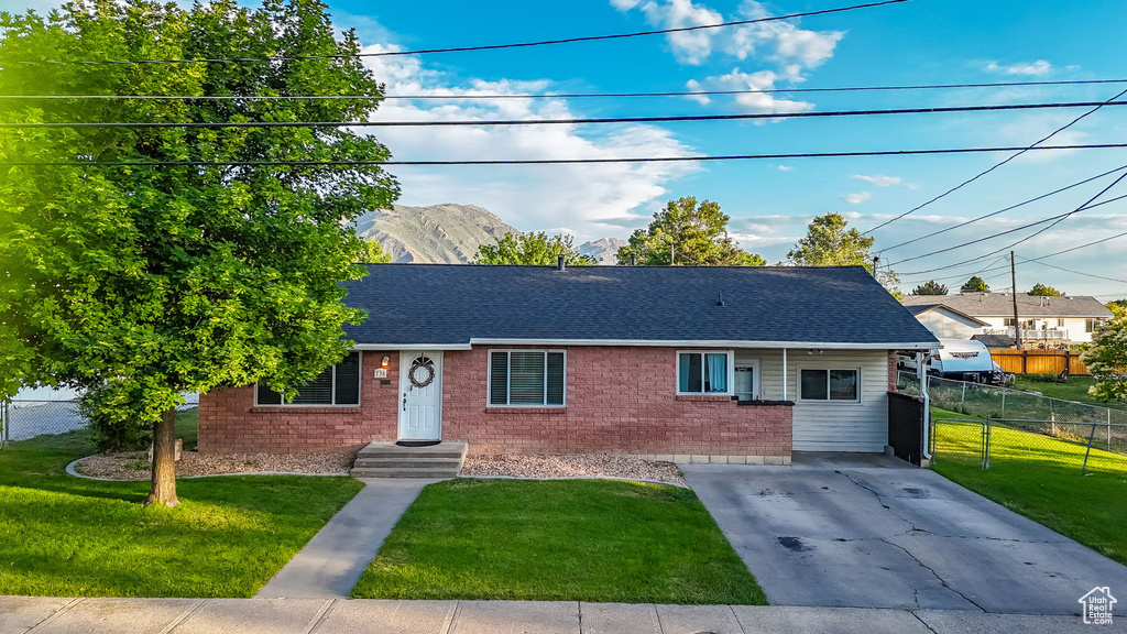 Ranch-style home featuring brick siding, a shingled roof, concrete driveway, and a mountain view