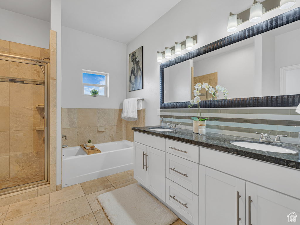 Bathroom with double vanity, a garden tub, a stall shower, and tile patterned floors
