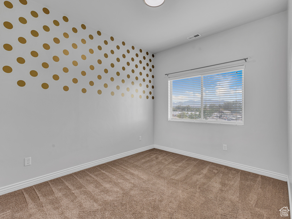 Carpeted spare room with baseboards
