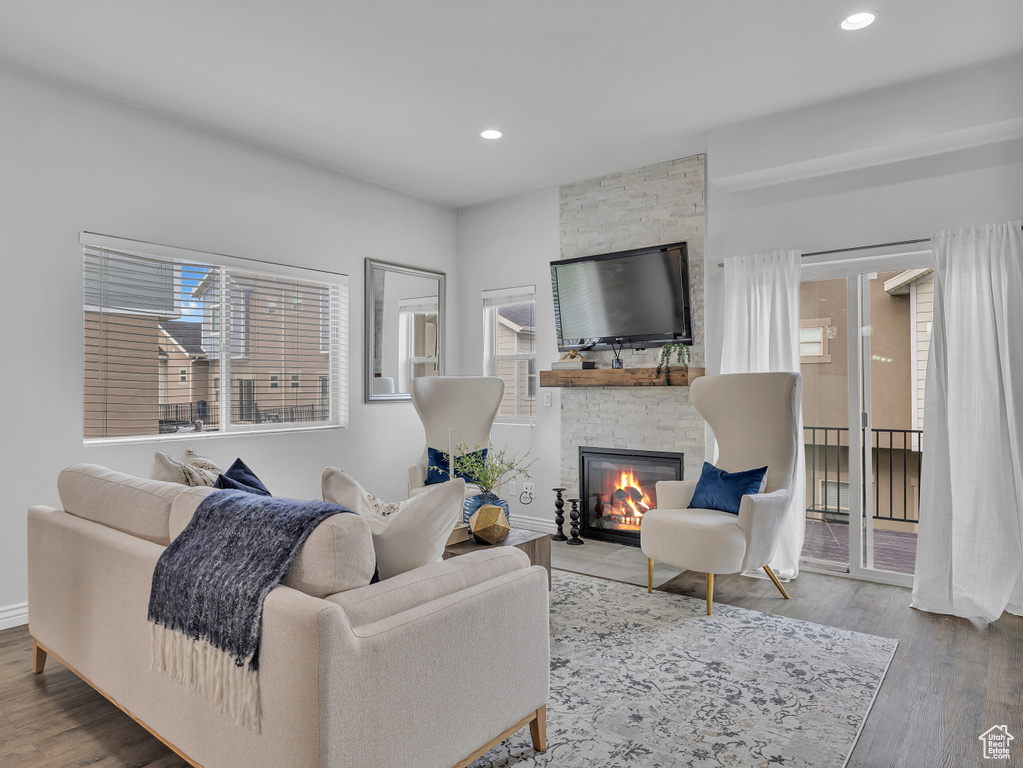 Living area with plenty of natural light, a fireplace, wood finished floors, and recessed lighting