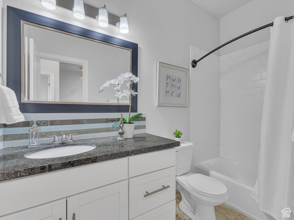 Bathroom featuring vanity, toilet, shower / tub combo with curtain, and tile patterned floors