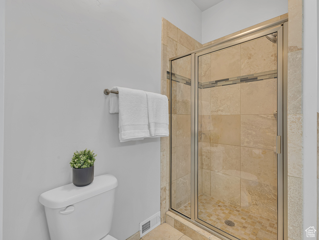 Full bath featuring toilet and a stall shower