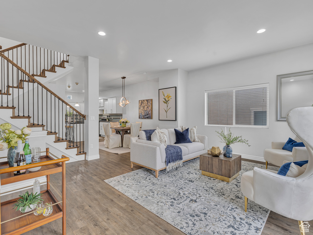 Living area featuring wood finished floors, stairway, recessed lighting, a chandelier, and baseboards
