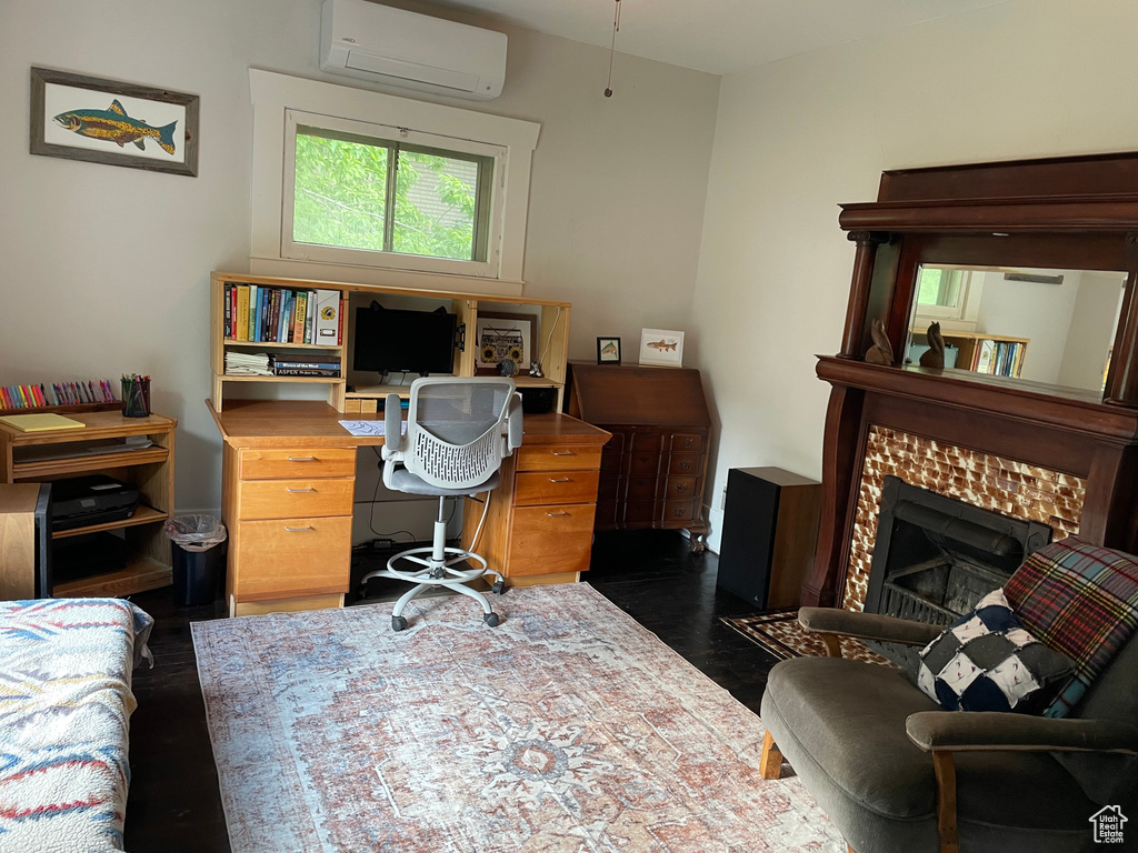 Office space featuring a wall mounted AC and dark wood-type flooring