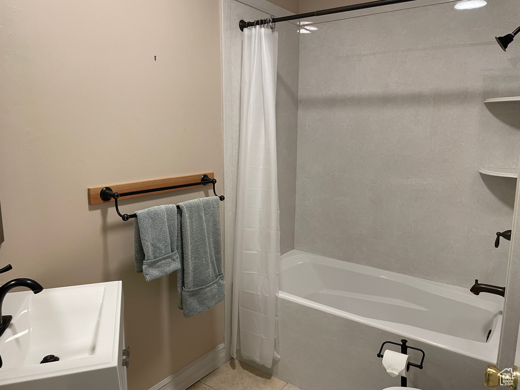 Full bath featuring shower / bath combo with shower curtain and tile patterned floors