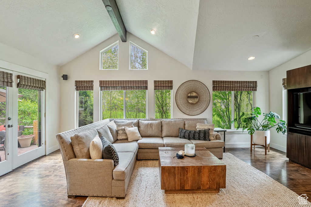 Living room featuring plenty of natural light, beamed ceiling, wood finished floors, a textured ceiling, and recessed lighting