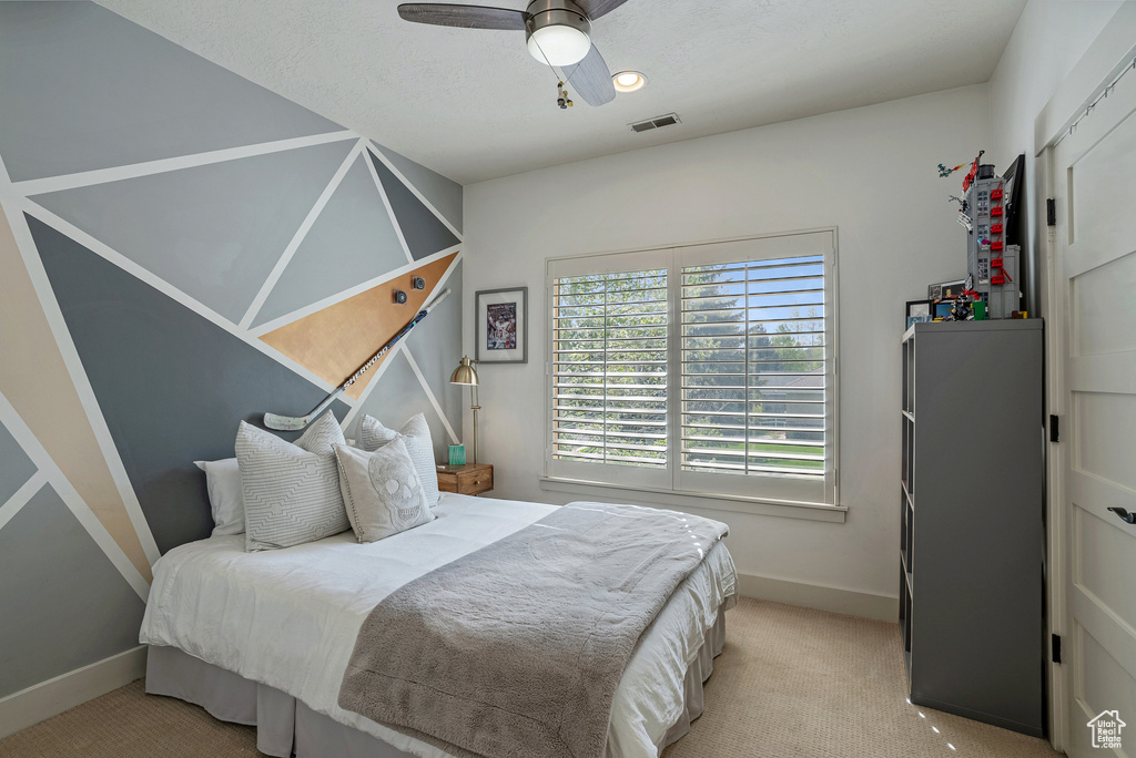 Bedroom featuring baseboards, light colored carpet, and a ceiling fan