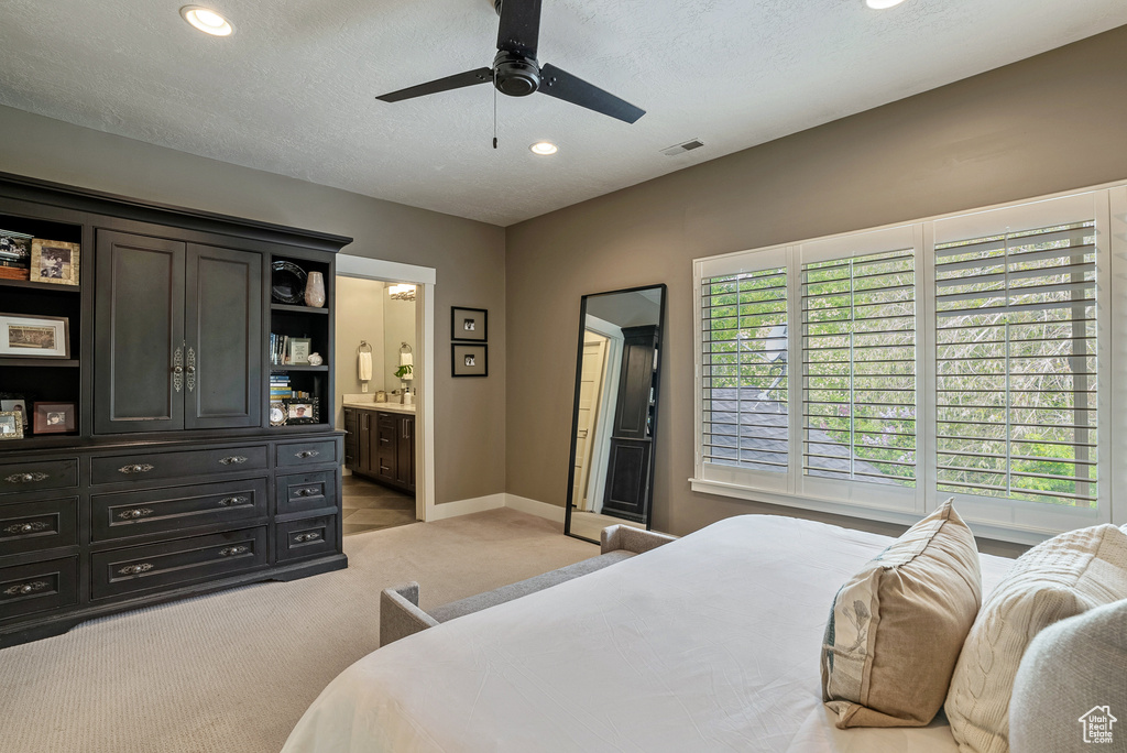Bedroom with light carpet, recessed lighting, baseboards, ensuite bathroom, and a ceiling fan