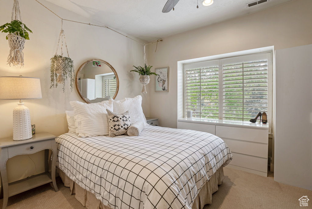 Bedroom with light carpet and a ceiling fan