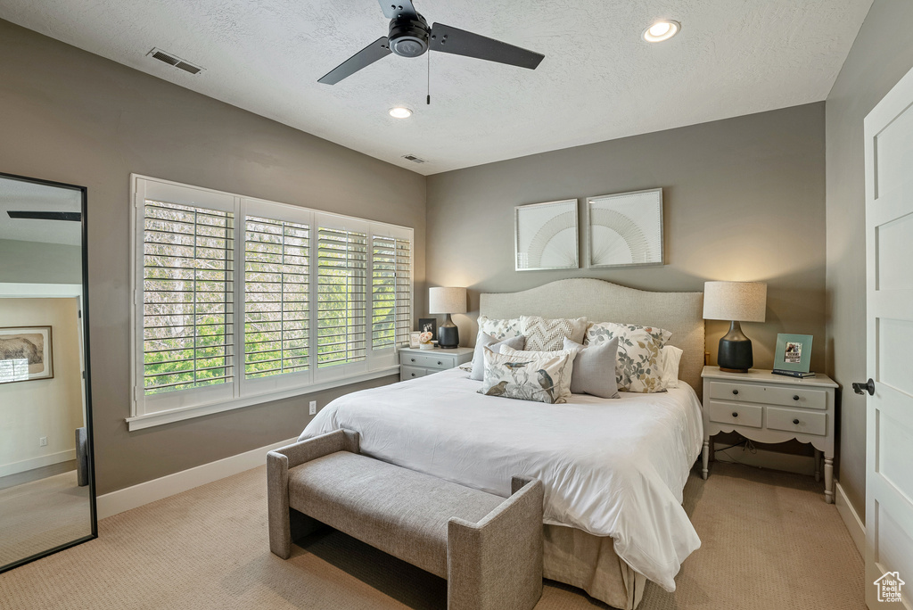 Bedroom with light colored carpet, a textured ceiling, baseboards, ceiling fan, and recessed lighting