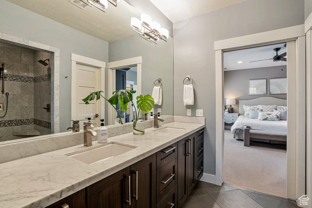 Bathroom with ensuite bathroom, double vanity, a stall shower, and tile patterned floors
