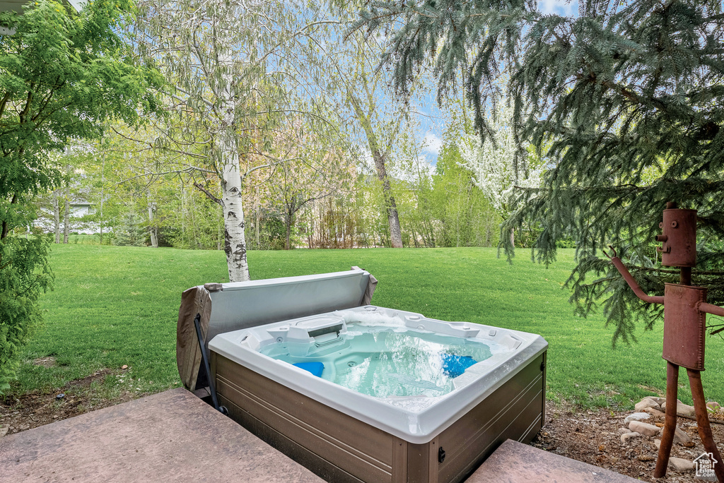 View of grassy yard featuring a hot tub