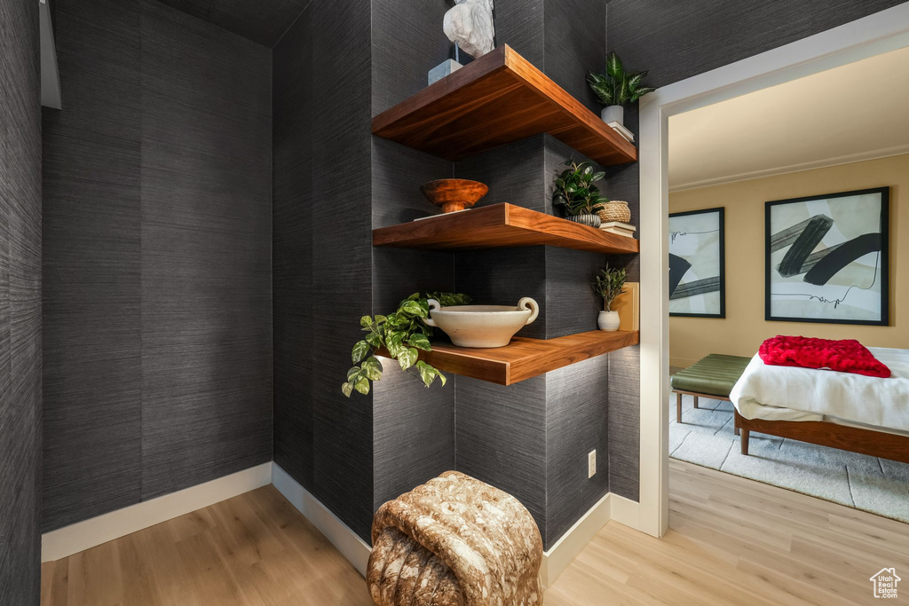 Detailed view of wood finished floors, baseboards, and crown molding
