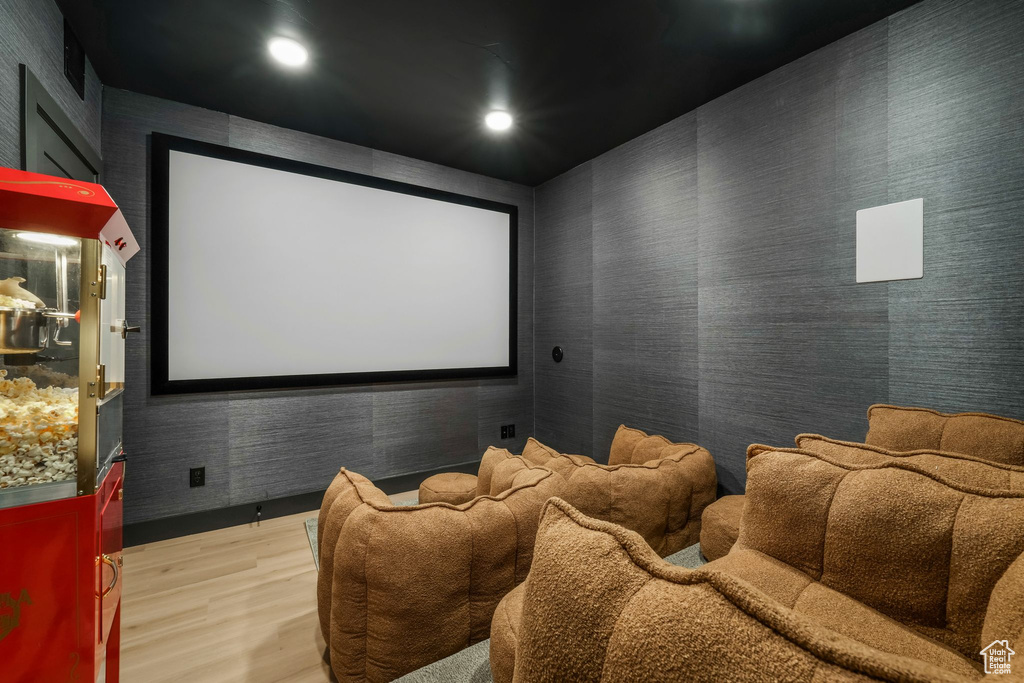 Cinema featuring light wood-style floors, wallpapered walls, and recessed lighting