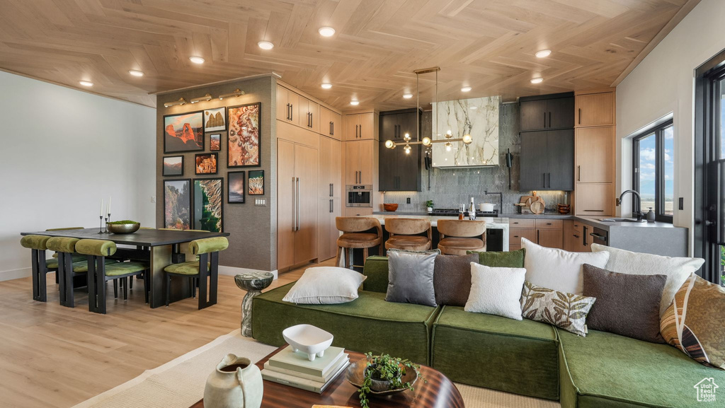 Living room with baseboards, light wood-style floors, and recessed lighting