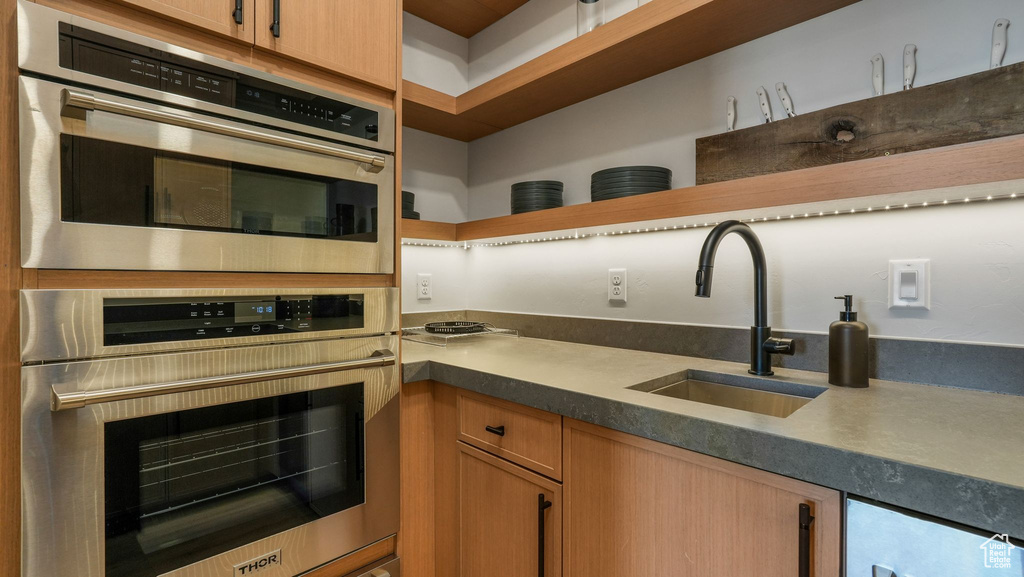 Kitchen featuring a sink, open shelves, and dark countertops
