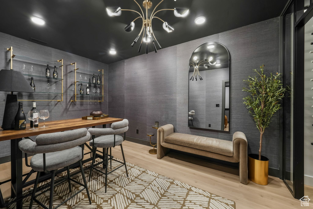 Indoor dry bar featuring wood finished floors and a chandelier