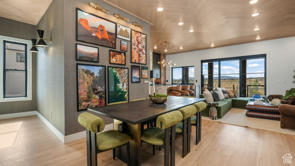 Dining space featuring light wood-style flooring, a chandelier, baseboards, and recessed lighting