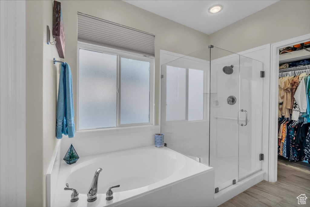 Bathroom featuring a shower stall, a spacious closet, and a garden tub
