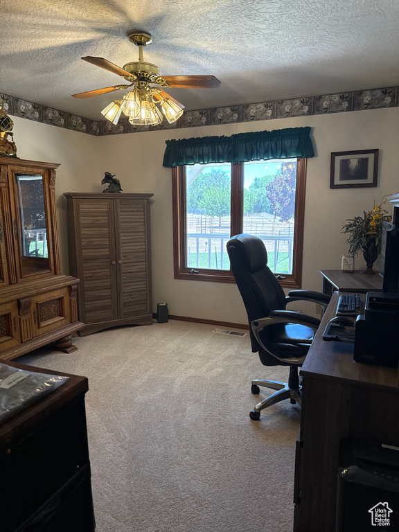 Office with a textured ceiling, light carpet, and ceiling fan
