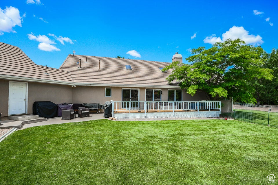Back of house with an outdoor living space, a chimney, a patio area, and stucco siding