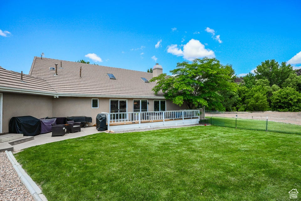 Rear view of property featuring a patio, a chimney, stucco siding, an outdoor hangout area, and a tiled roof