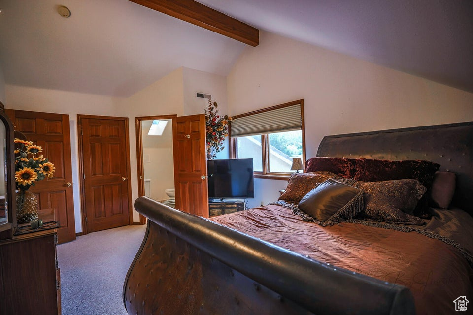 Bedroom with light carpet and connected bathroom