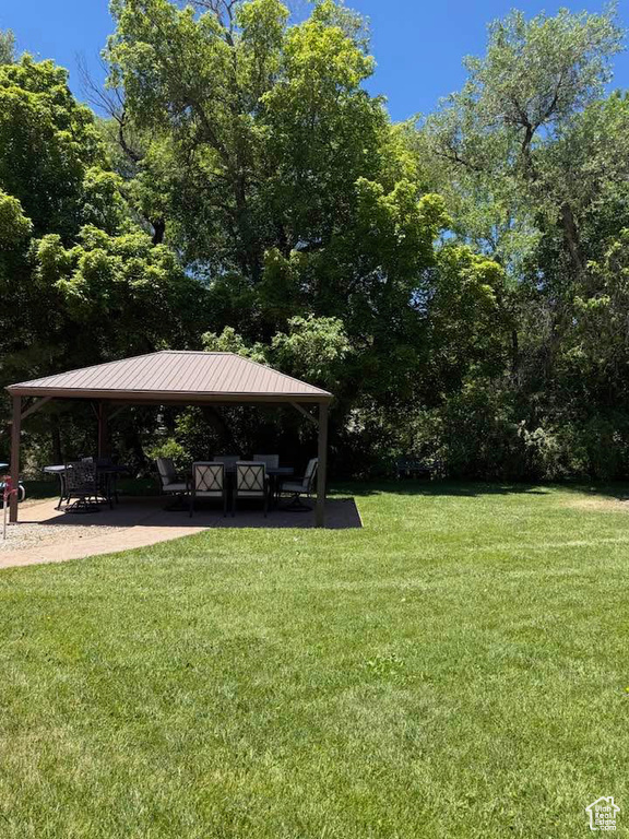 View of green lawn featuring a gazebo and a patio