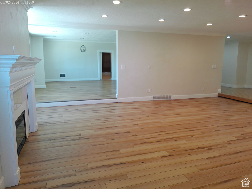 Unfurnished living room featuring a fireplace, light wood-type flooring, recessed lighting, and baseboards