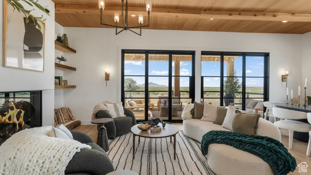 Living room featuring wood ceiling with exposed beams, wood finished floors, and a chandelier