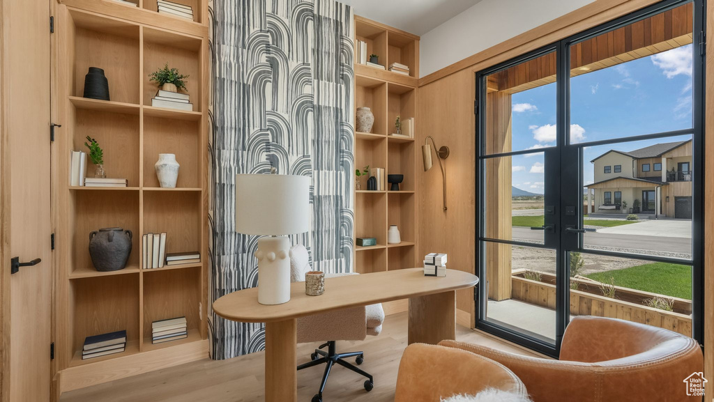 Office area with french doors, built in shelves, and wood finished floors