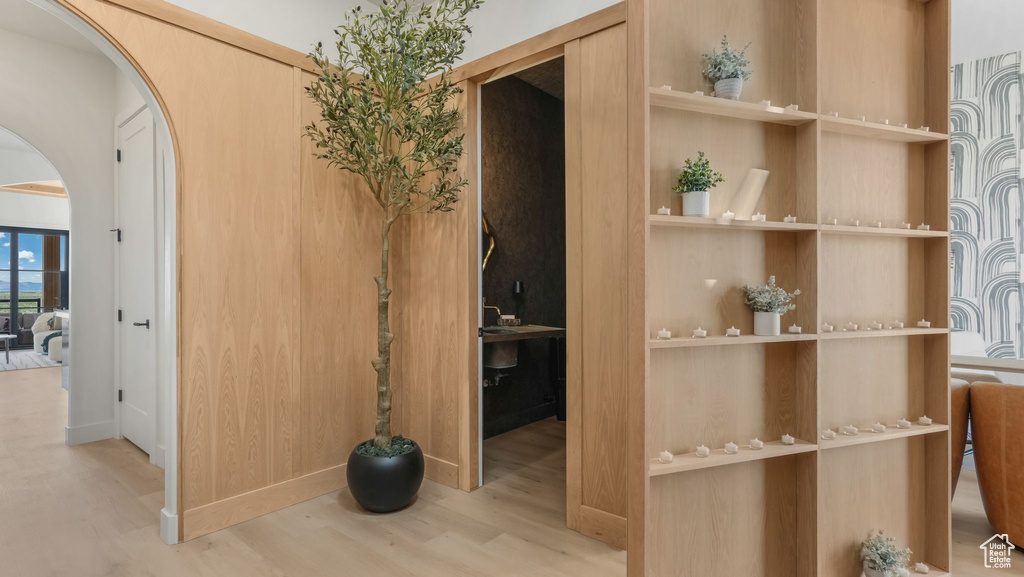 Hallway with arched walkways and wood finished floors