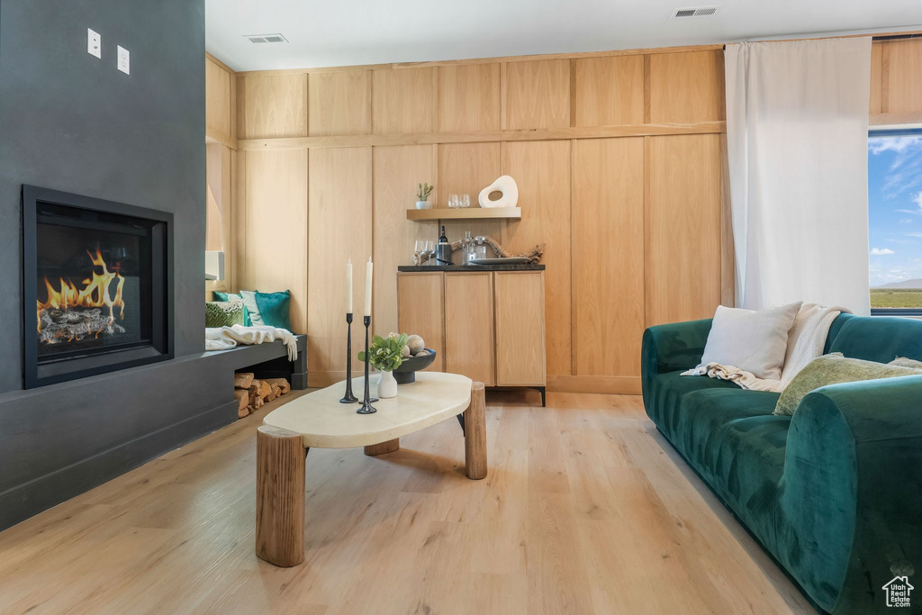 Living area with a glass covered fireplace and light wood finished floors