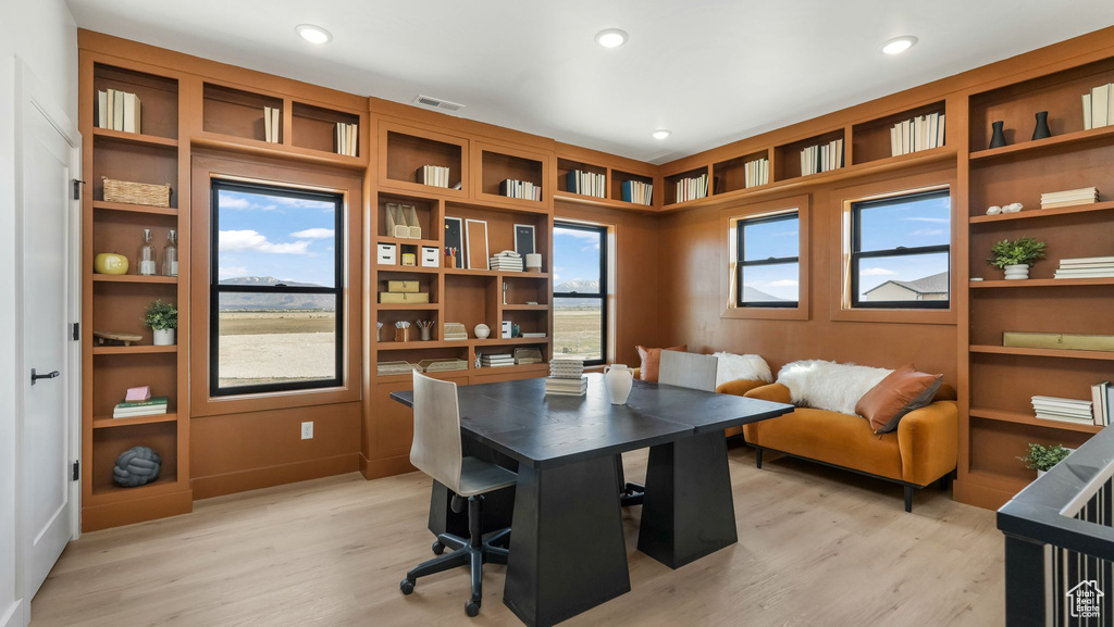 Office area with light wood-style flooring and recessed lighting