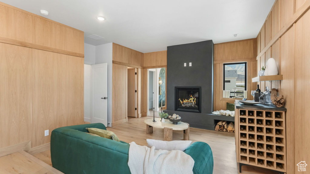 Living room with a fireplace, light wood-style floors, and baseboards
