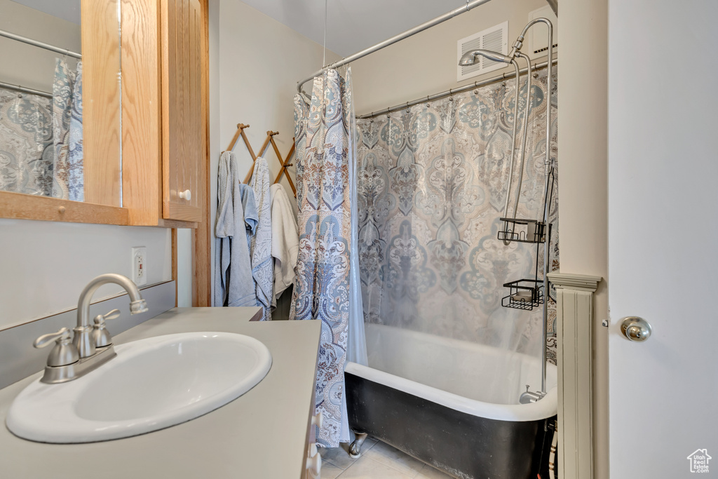 Full bath featuring shower / tub combo, vanity, and tile patterned floors