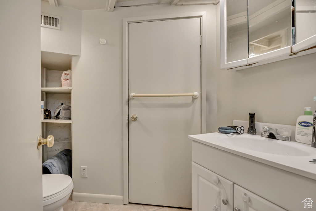 Bathroom featuring vanity, toilet, and tile patterned floors
