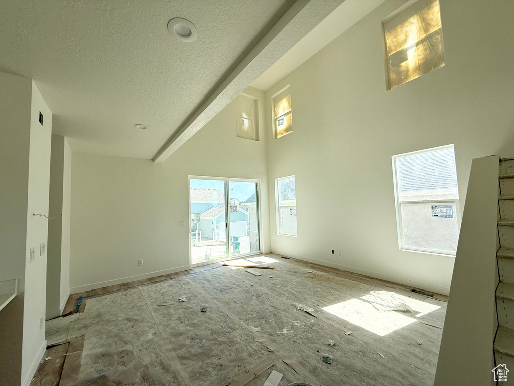Spare room with a towering ceiling and a textured ceiling