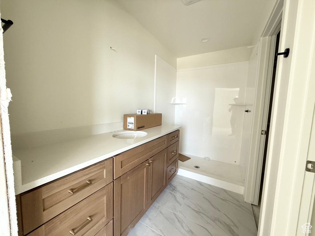 Bathroom with vanity and marble look tiles