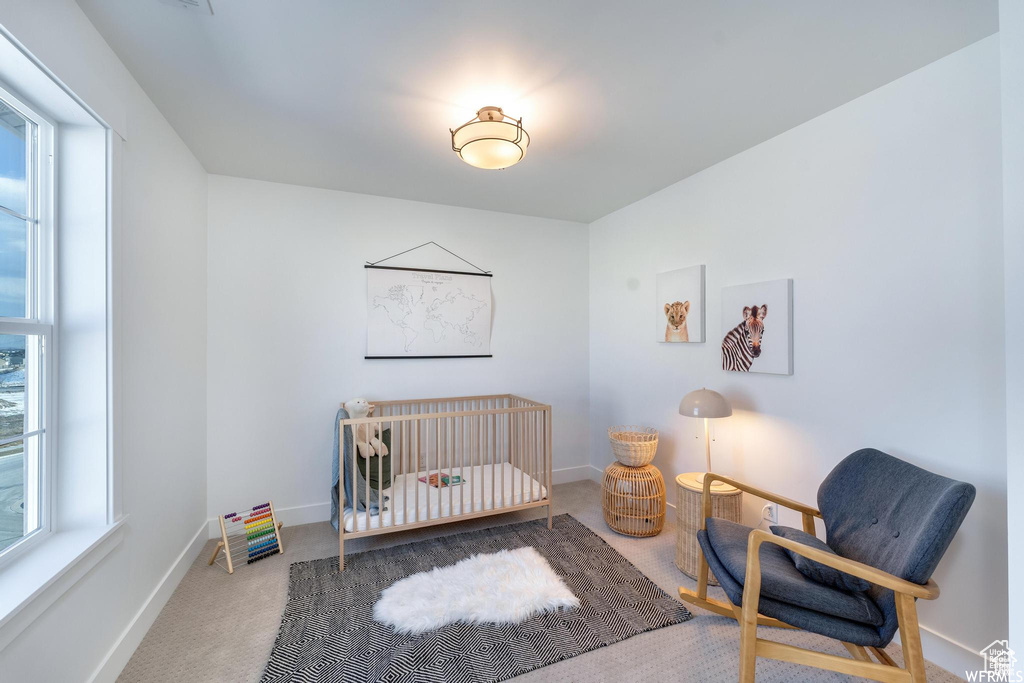 Bedroom featuring carpet, baseboards, and a crib