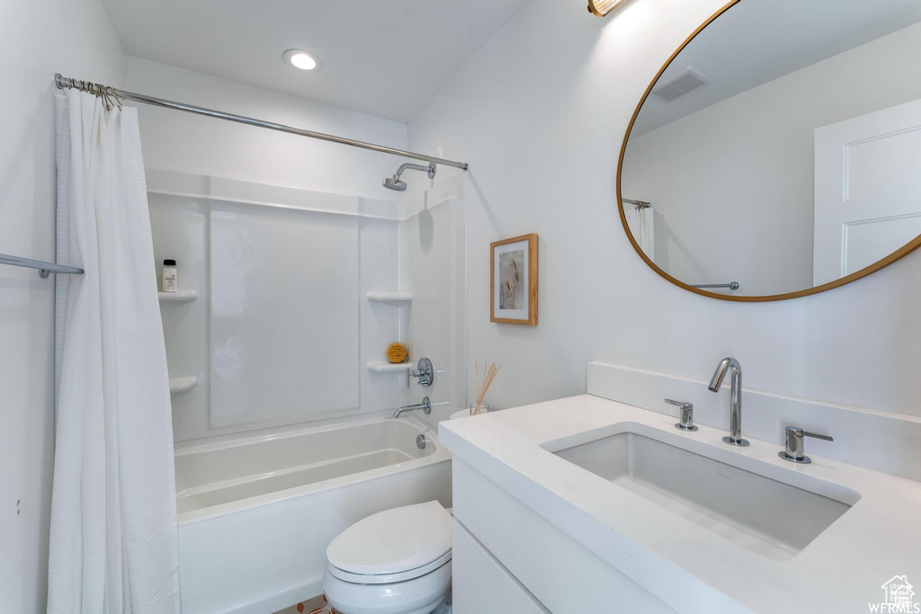 Full bathroom with vanity, shower / tub combo, toilet, and recessed lighting