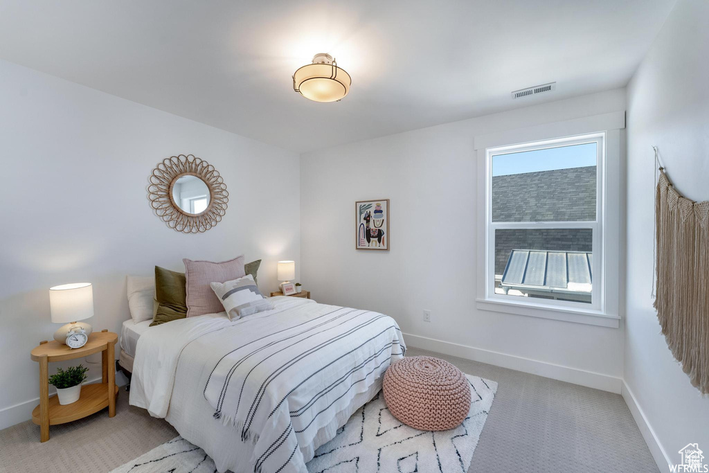 Bedroom featuring light carpet and baseboards