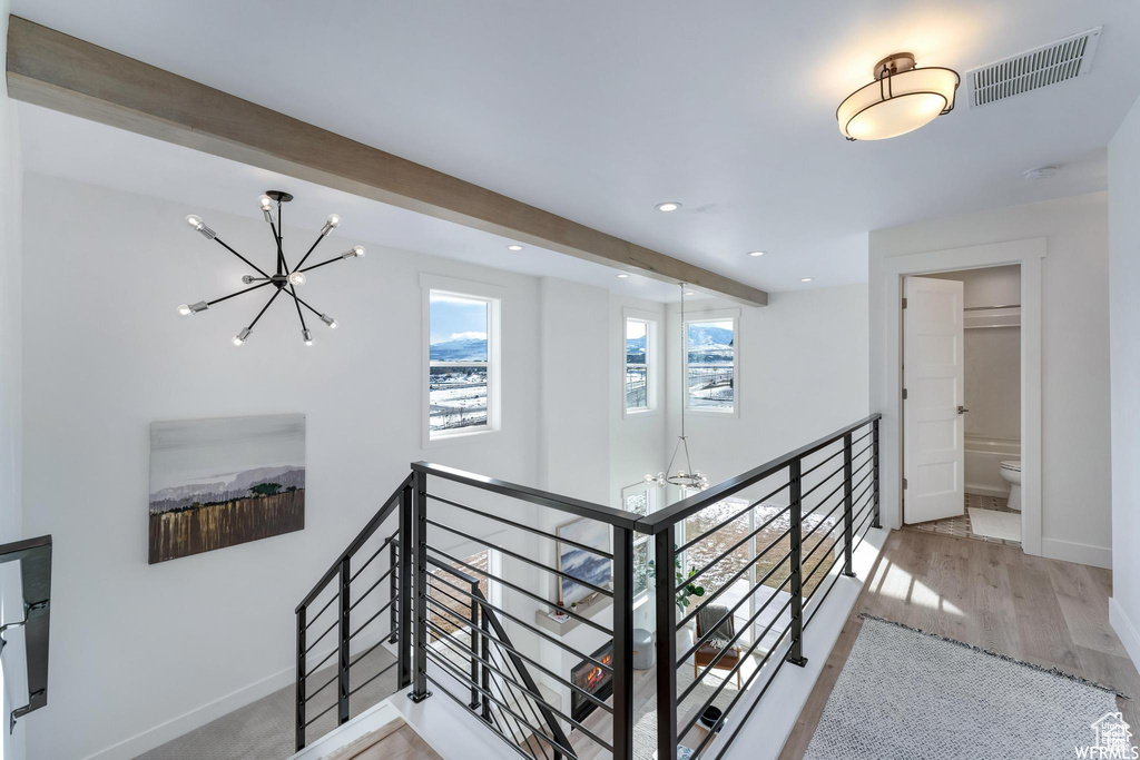 Hallway with a chandelier, an upstairs landing, baseboards, wood finished floors, and recessed lighting