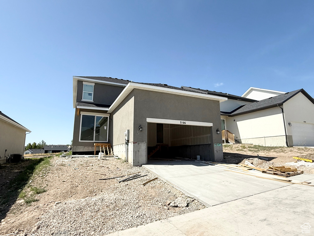 View of front of property with a garage, stucco siding, and concrete driveway