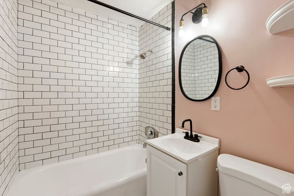 Bathroom with toilet, vanity, and shower / bath combination